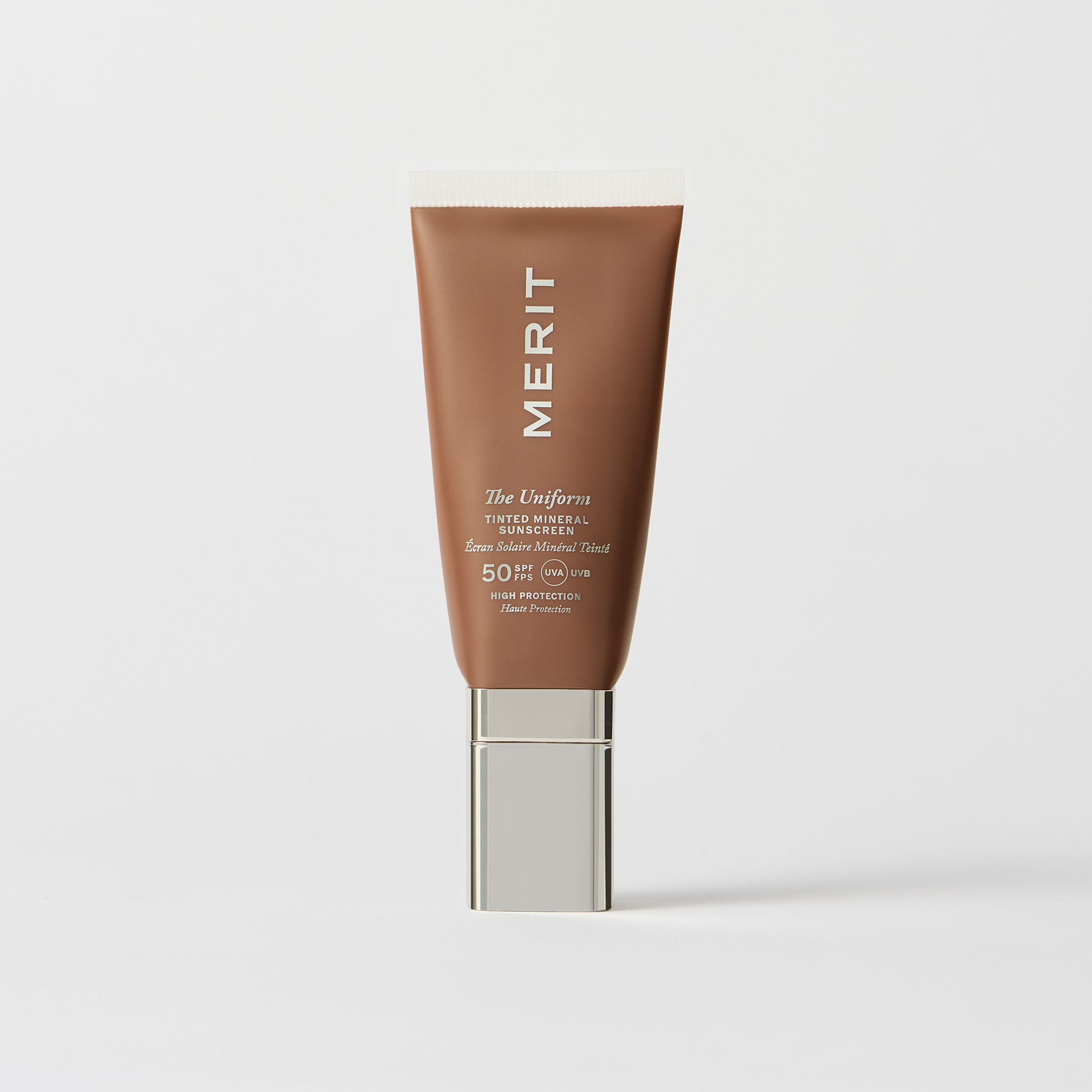 Master || A tube of MERIT brand mineral sunscreen with a sheer tint finish, providing broad spectrum 50 UVA/UVB protection, displayed against a white background. Shade 6