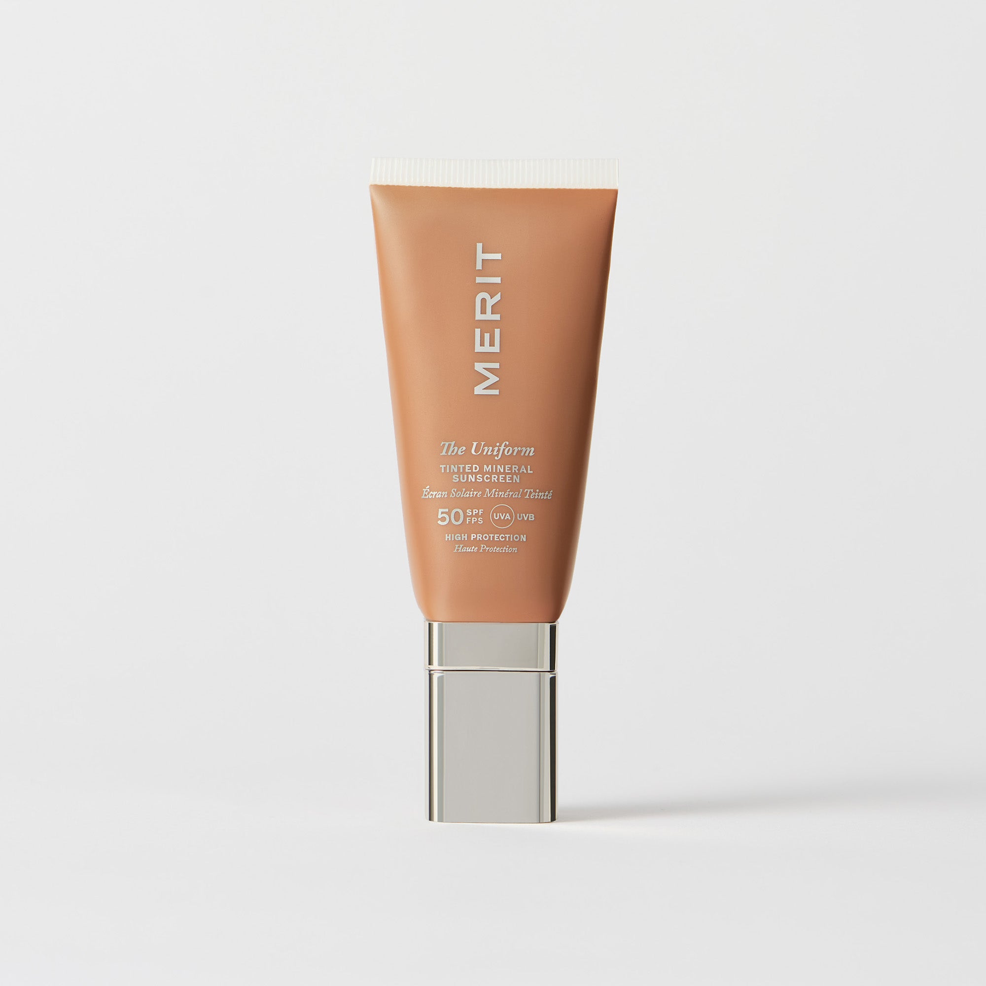 Master || A tube of MERIT brand mineral sunscreen with a sheer tint finish, providing broad spectrum 50 UVA/UVB protection, displayed against a white background. Shade 12