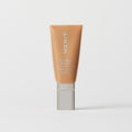 Master || A tube of MERIT brand mineral sunscreen with a sheer tint finish, providing broad spectrum 50 UVA/UVB protection, displayed against a white background. Shade 14 