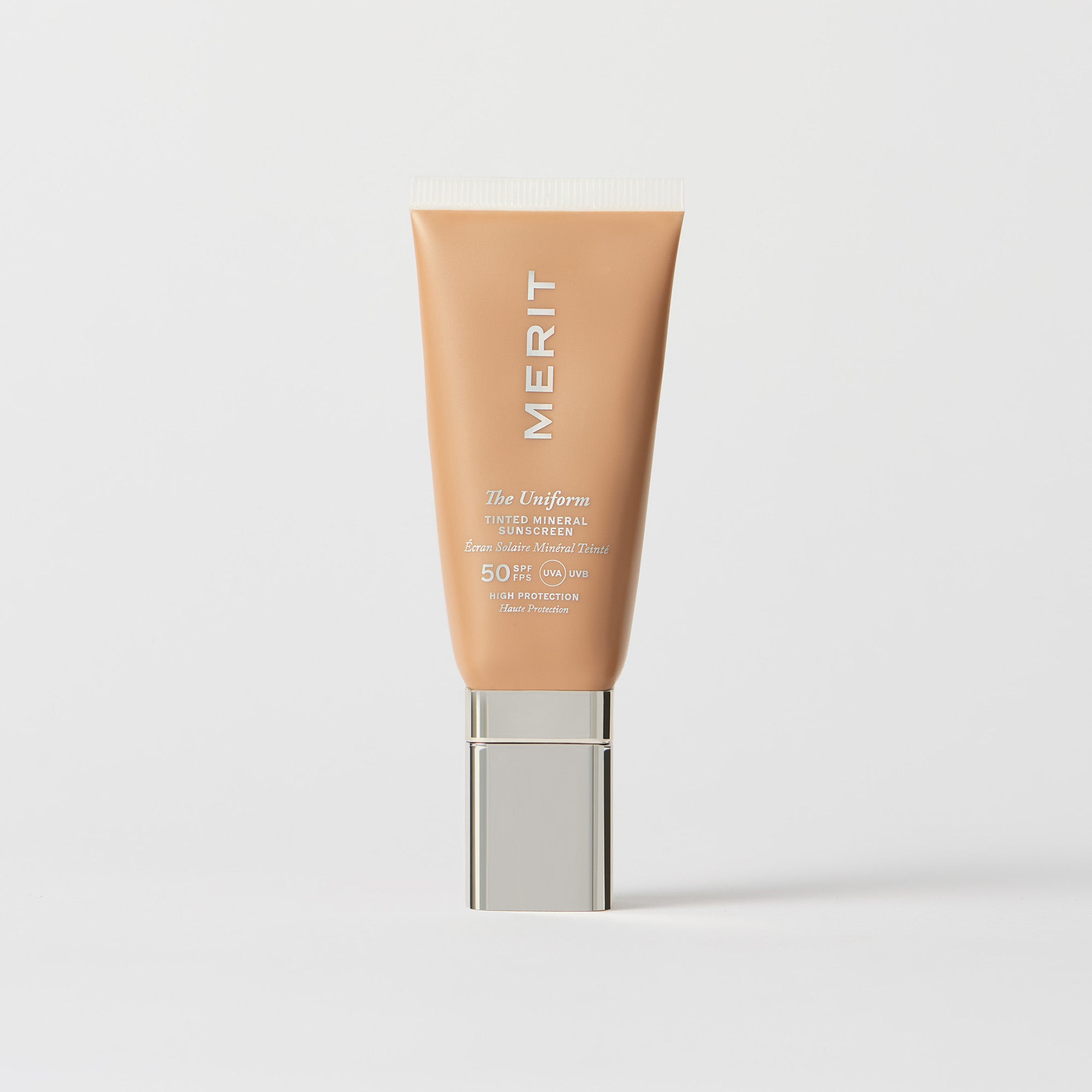 Master || A tube of MERIT brand mineral sunscreen with a sheer tint finish, providing broad spectrum 50 UVA/UVB protection, displayed against a white background. Shade 18