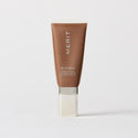 Master || A tube of MERIT brand mineral sunscreen with a sheer tint finish, providing broad spectrum 45 UVA/UVB protection, displayed against a white background. Shade 06