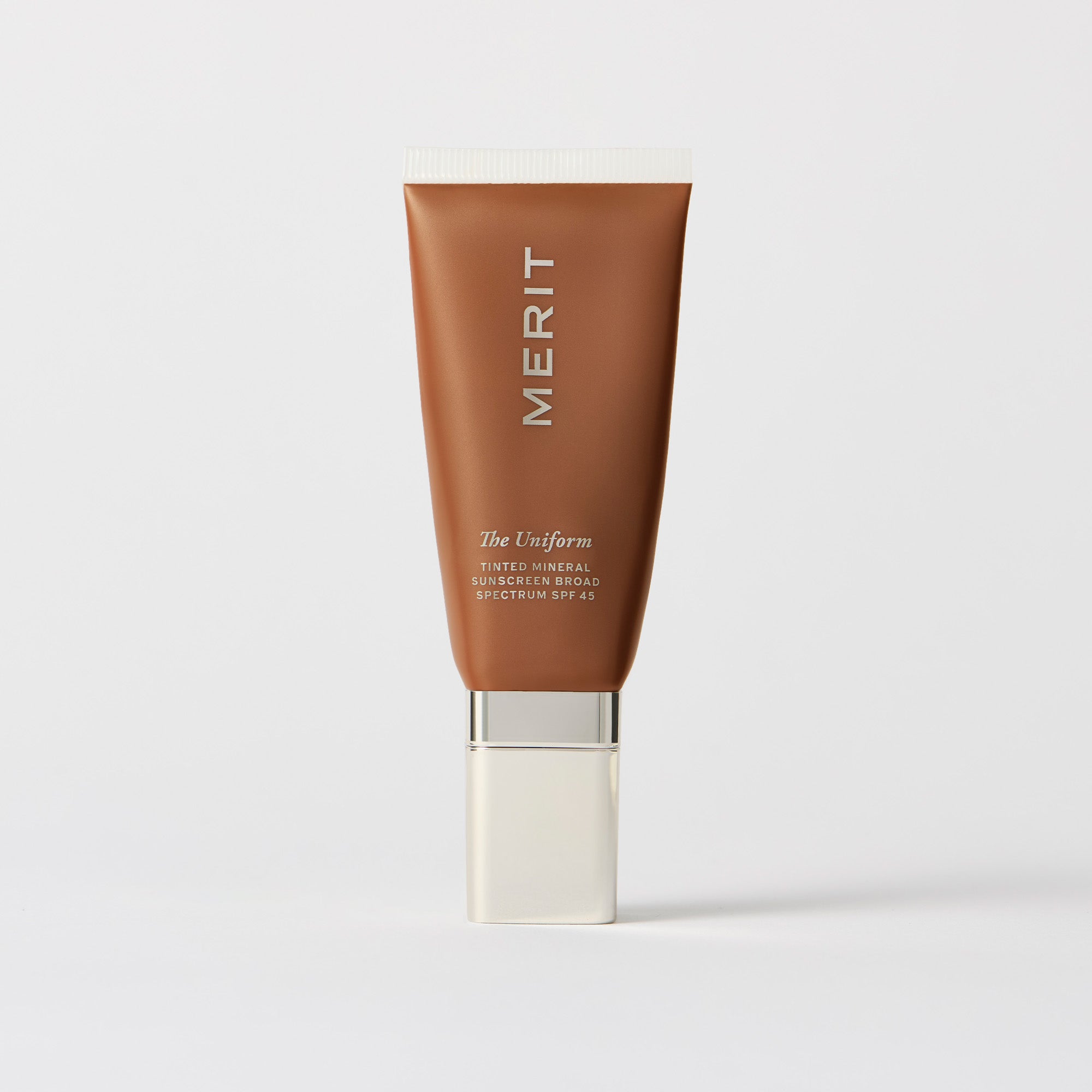 Master || A tube of MERIT brand mineral sunscreen with a sheer tint finish, providing broad spectrum 45 UVA/UVB protection, displayed against a white background. Shade 08