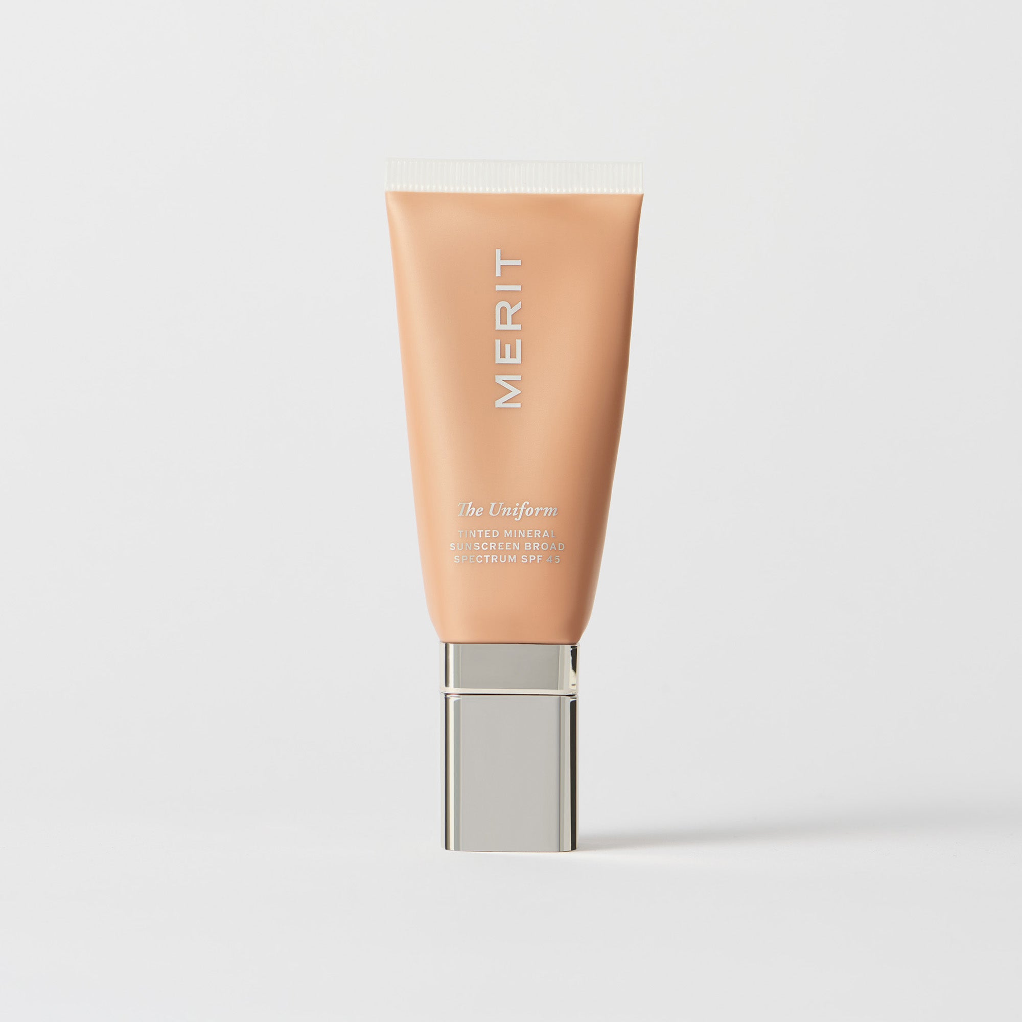 Master || A tube of MERIT brand mineral sunscreen with a sheer tint finish, providing broad spectrum 45 UVA/UVB protection, displayed against a white background. Shade 22