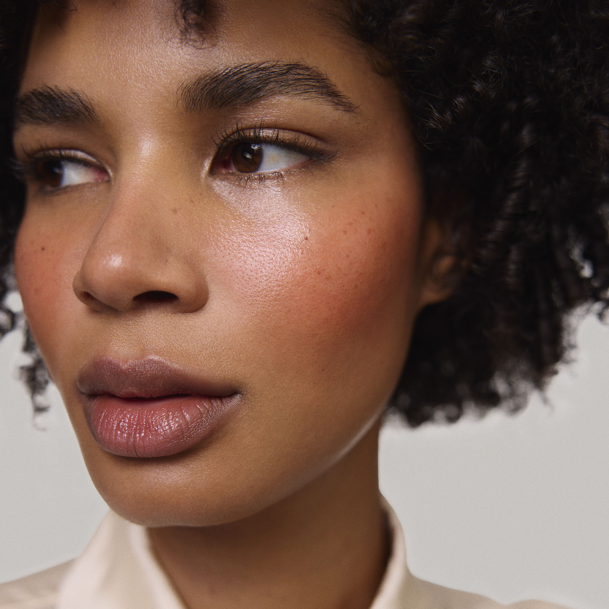 Persimmon | face::deep | Model is wearing Flush Balm in shade Persimmon.