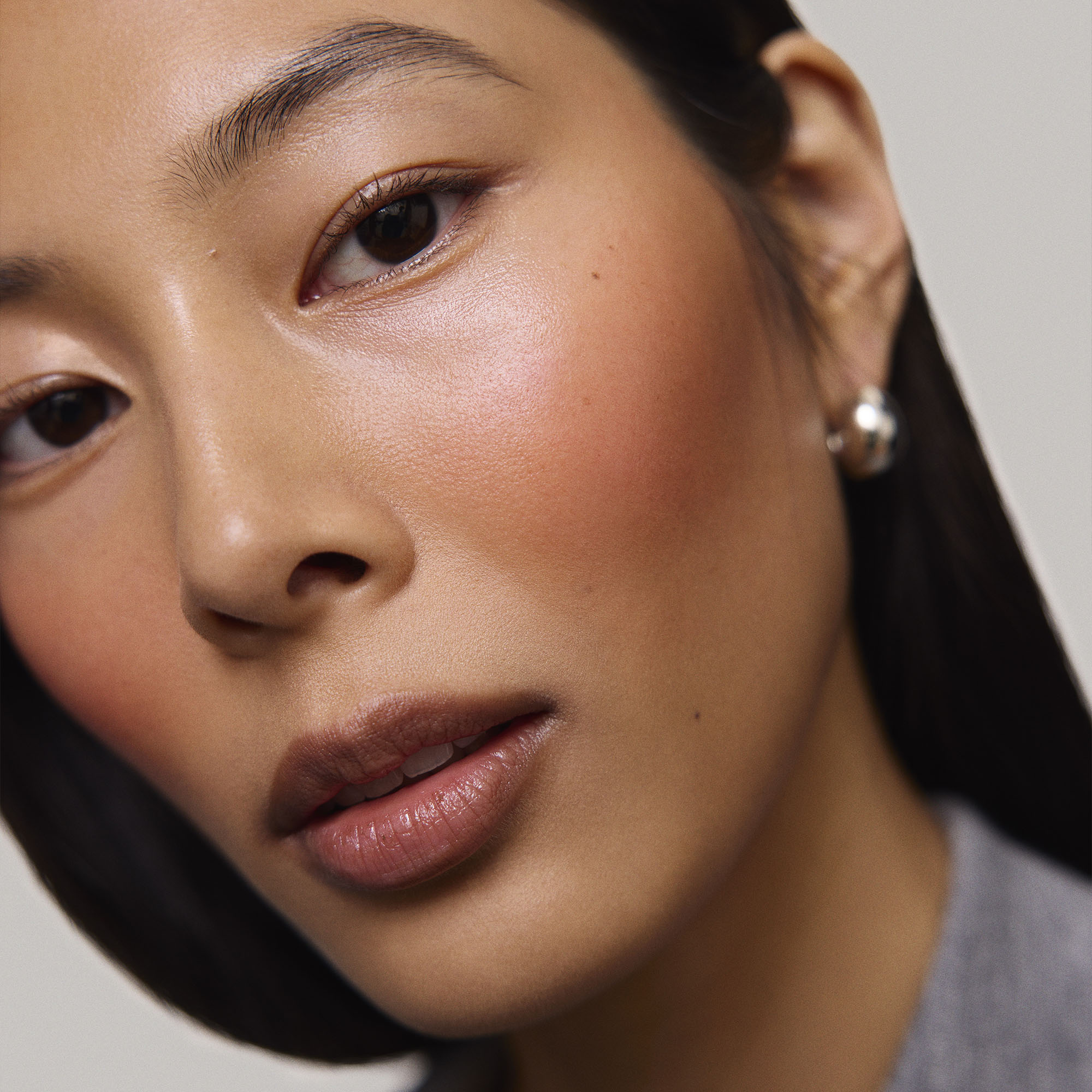 Persimmon | face::medium |  Model is wearing Flush Balm in shade Persimmon.