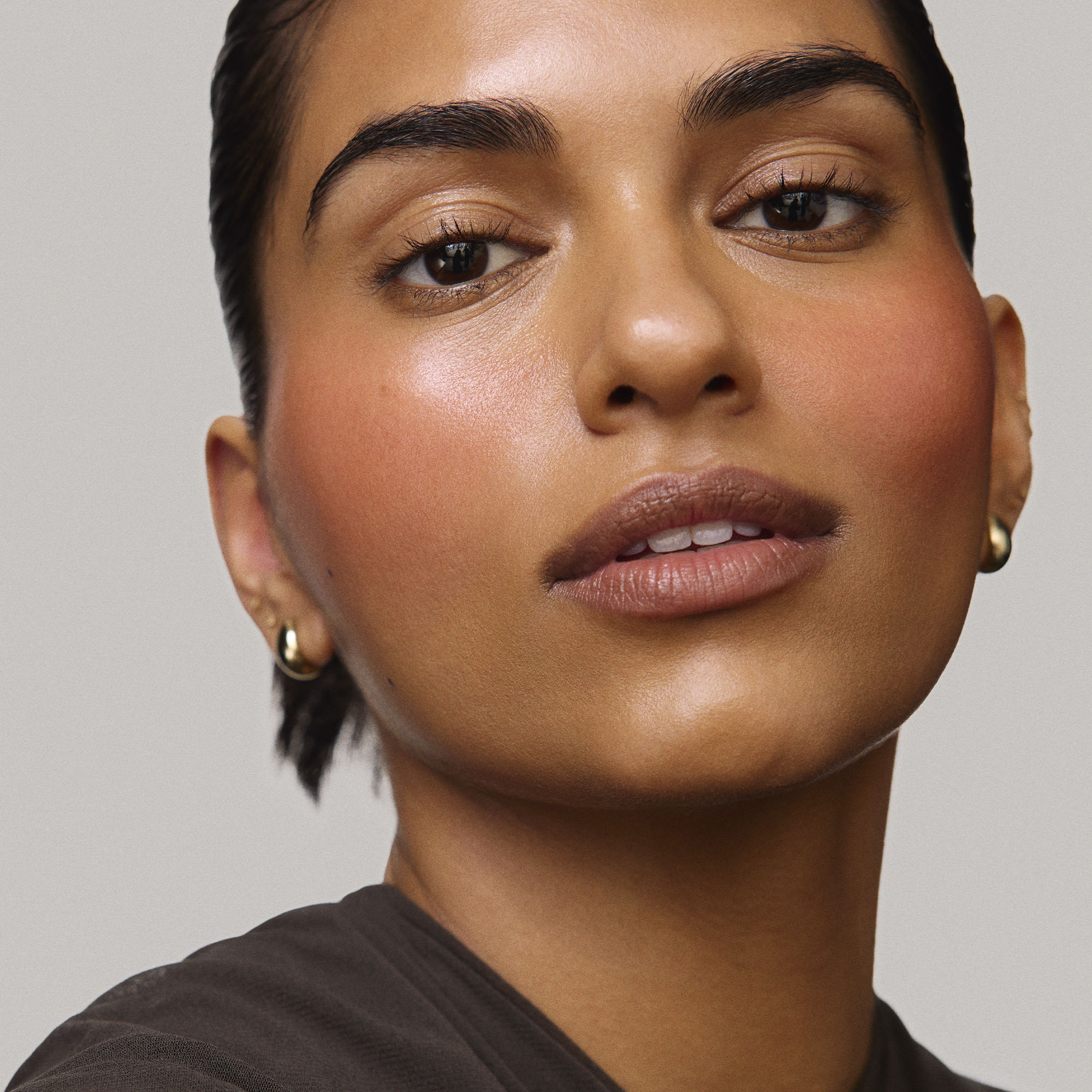 Persimmon | face::medium |  Model is wearing Flush Balm in shade Persimmon.