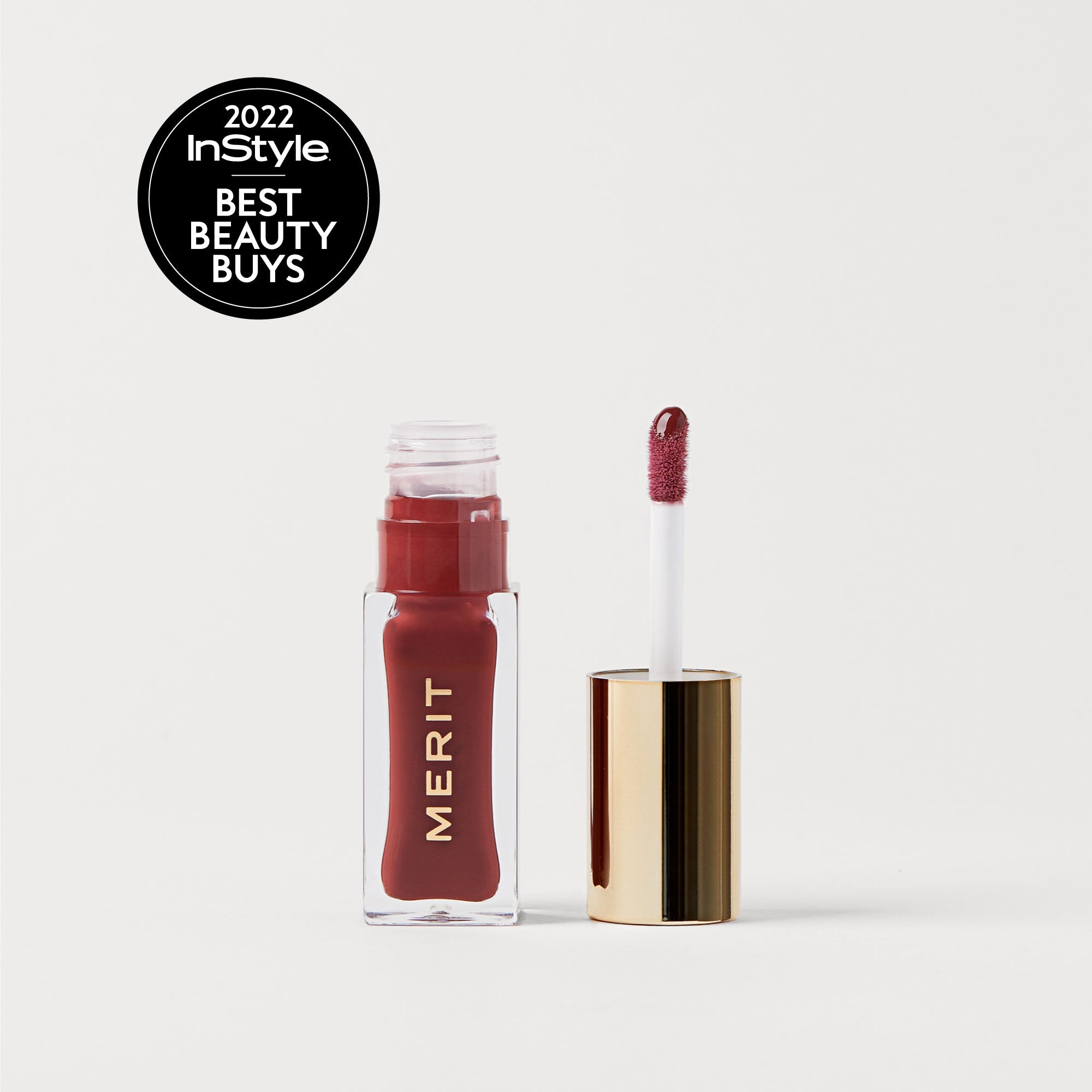 Sangria | | A bottle of Merit lip oil in  shade Sangria displayed next to its applicator. 2022 InStyle Best Beauty Buy