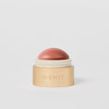 Master ||  A cream blush balm by Merit Beauty in color Beverly Hills and gold body.